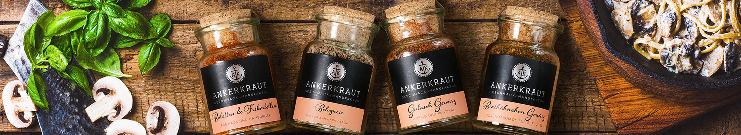 Ankerkraut Korkengläser mit ausgesuchten Gewürzmischungen, arrangiert auf einem Holzbrett mit frischem Gemüse und Käutern.