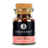 Chiliflocken von Ankerkraut im Korkenglas auf weißem Hintergrund.