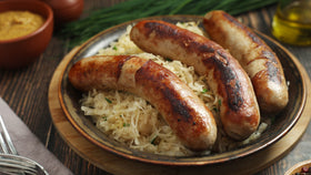 Nahaufnahme Teller mit Bratwurst auf Sauerkraut.