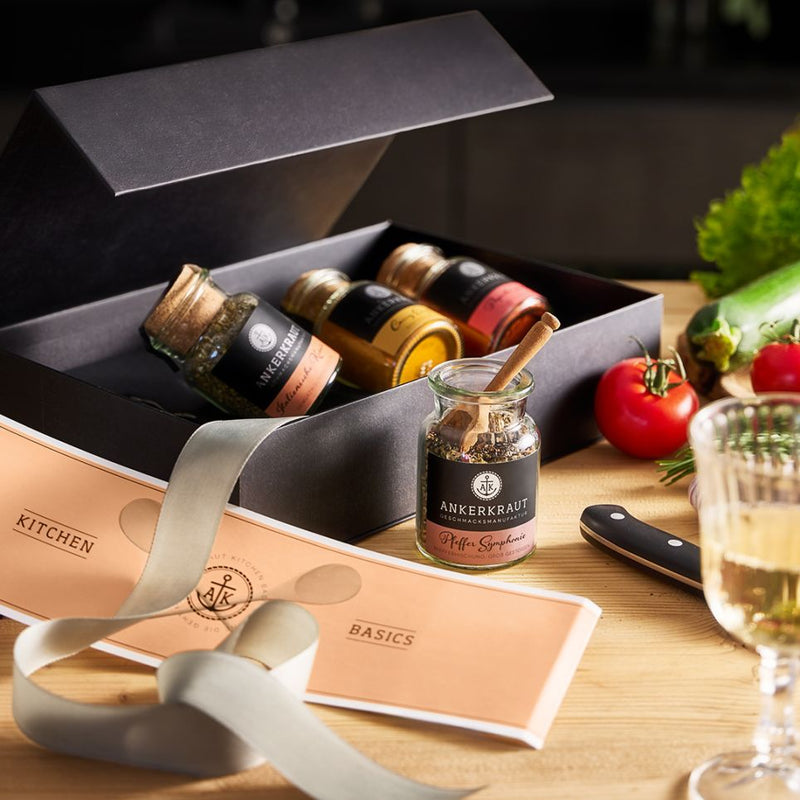 Kitchen Basics Geschenk-Box mit geöffnetem Deckel und einem geöffneten Korkenglas davor, umgeben von Deko.